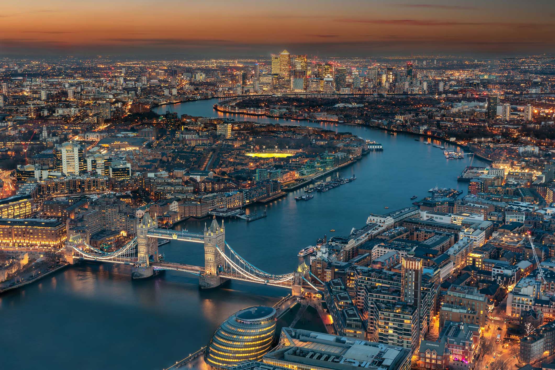 Aerial view of London during evening time. Aerial view of London: from the Tower Bridge along the rover Thames to the financial district Canary Wharf during evening time