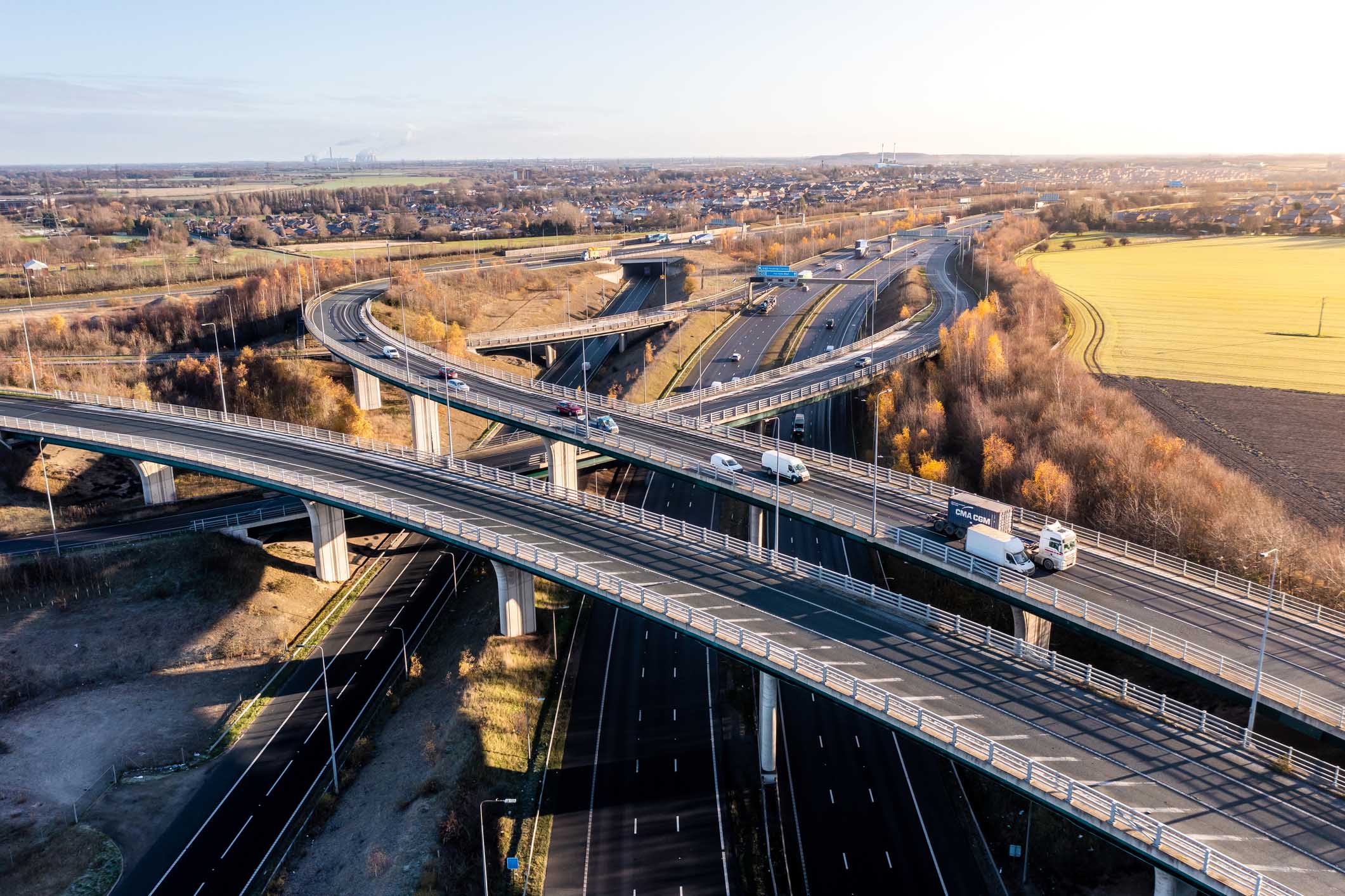 Aerial view of a complex motorway road layout in the UK countryside. FERRYBRIDGE, YORKSHIRE, UK - DECEMBER 14, 2022. An aerial view above a complex motorway junction with slip roads and overbridges connecting the M62 and A1 motorways in the UK